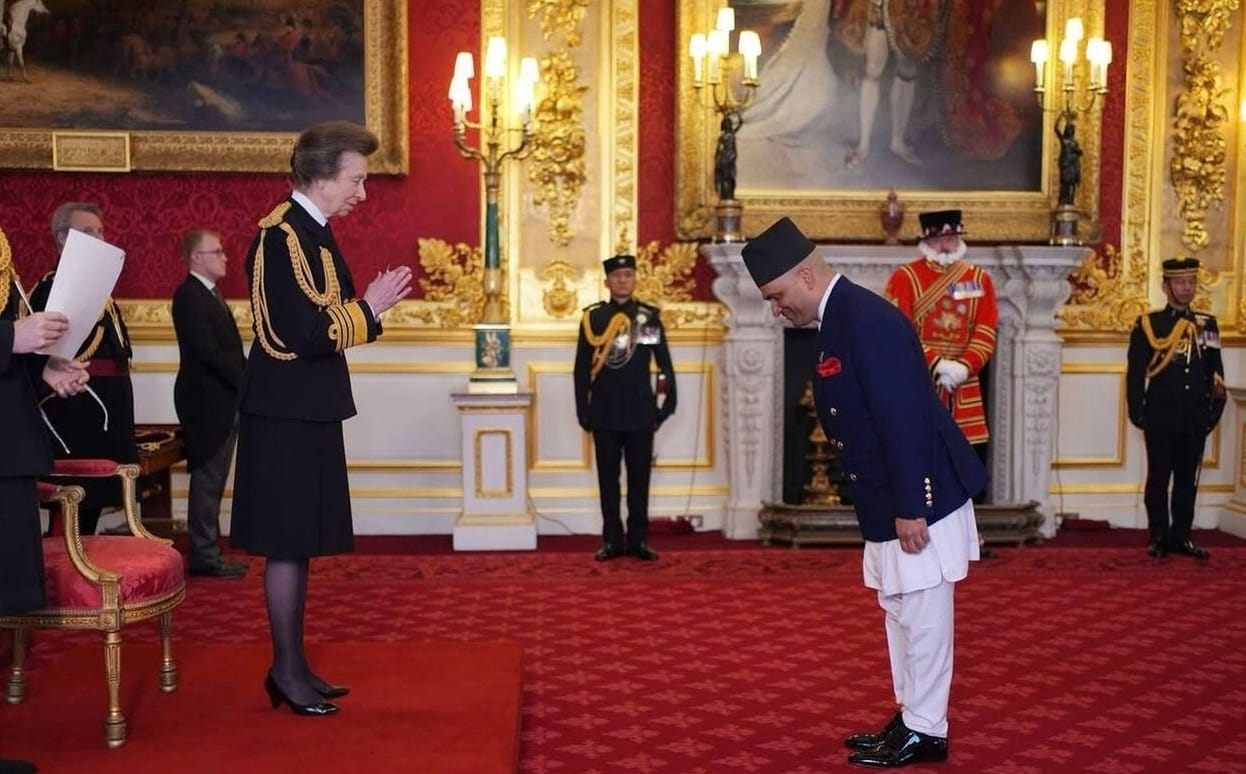 A person receiving an award from royalty, and bowing.