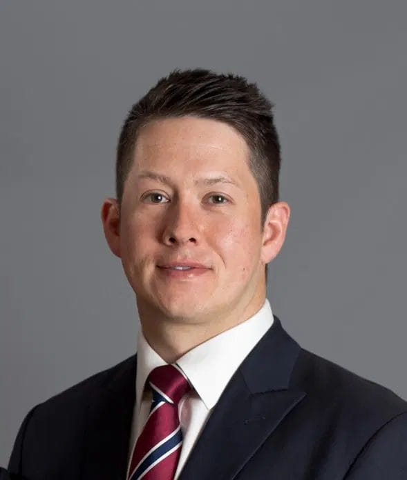 John Adams wearing a suit and red tie, after becoming a Top 100 Influential Person.